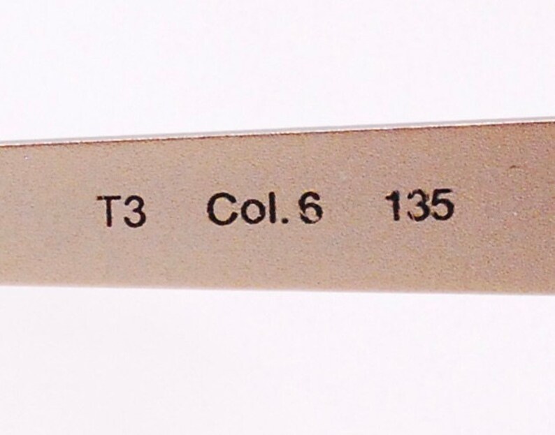 Op de afbeelding: Close-up van een zilverkleurig metalen frame met de tekst "T3 Col. 6 135" erop gedrukt.