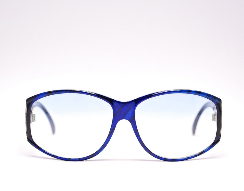 Op de afbeelding: Blauwe en zwarte gepatenteerde bril met een blauwe tint.