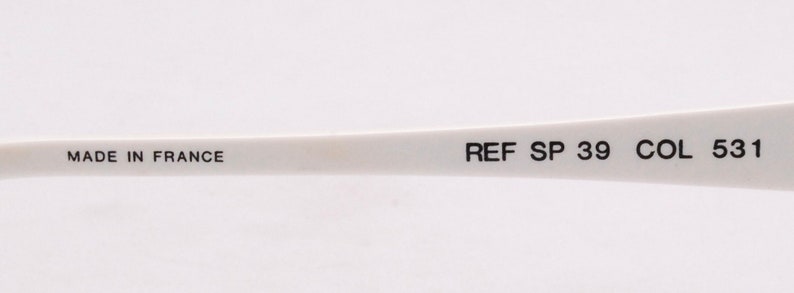 Peut inclure: Gros plan sur une monture en plastique blanche avec le texte "MADE IN FRANCE" et "REF SP 39 COL 531" imprim&eacute; dessus.