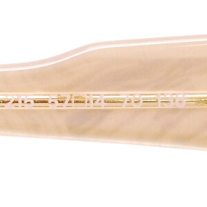 May include: Close-up of the inside of a pair of sunglasses with the text "2165 52 17 140 135" printed on the inside of the arm.