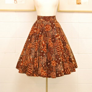 Peut inclure: Une jupe à motifs marrons et noirs avec une forme de cercle complet. La jupe est sur un mannequin et a une taille haute.