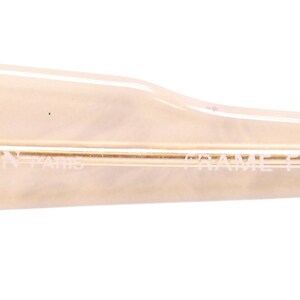 May include: Close-up of the side of a pair of beige sunglasses with the text "LANVIN - PARIS - FRAME FRANCE" printed on the frame.