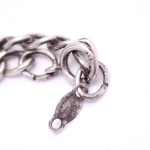 May include: Close-up of a silver chain bracelet with a clasp that reads "925" and "VAN DELL'Y STERLING NEW YORK".