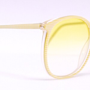 May include: A pair of yellow tinted eyeglasses with a clear plastic frame. The frame has a textured pattern.