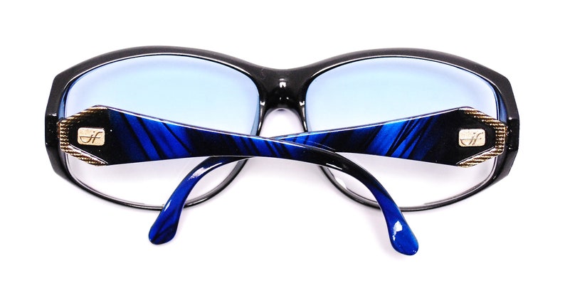 Op de afbeelding: Zwarte en blauwe zonnebril met een blauw-zwart gestreept patroon op de pootjes. De zonnebril heeft een gouden logo op de pootjes dat "D.I.F." zegt.