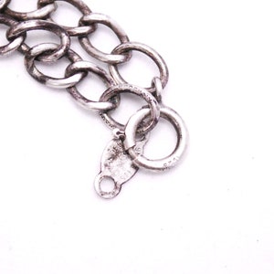 May include: Close-up of a silver chain bracelet with a lobster clasp and a tag that reads "925 ITALY".