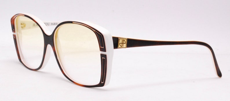 Peut inclure: Lunettes de vue en plastique blanc et marron avec un logo dor&eacute; "JP Paris".
