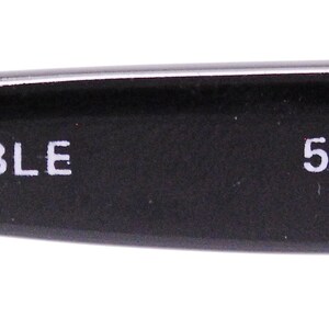 May include: Close-up of the inside of a black eyeglass frame with the text "BLUE MARBLE 58-13-140mm" printed in white.