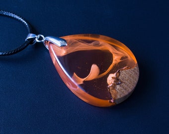 An elegant pendant made of epoxy resin with a wooden base in shades of orange. The perfect gift ,that will accentuate her individual style.