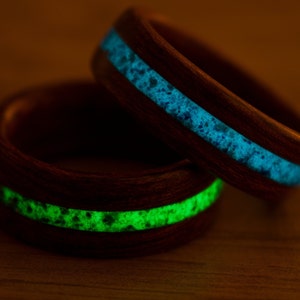 Puede incluir: Dos anillos de madera con una incrustaci&oacute;n verde y azul brillante. Los anillos est&aacute;n apilados uno encima del otro.