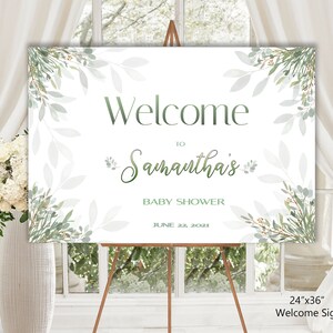 May include: Welcome sign for a baby shower with a green leafy design. The sign says "Welcome to Samantha's Baby Shower June 22, 2021". The sign is 24 inches by 36 inches.