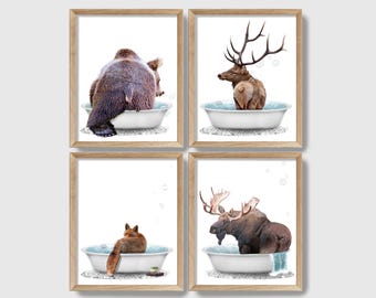 May include: Set of four printable art prints featuring a bear, elk, moose, and fox taking a bath in a bathtub. The prints have a white background and are framed in a light brown wood frame.