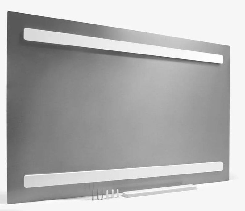 K&ouml;nnte beinhalten: Die R&uuml;ckseite eines grauen Metallbilderrahmens mit zwei wei&szlig;en Aufh&auml;ngeb&auml;ndern und einer wei&szlig;en Aufh&auml;ngeleiste. Der Rahmen befindet sich auf einer wei&szlig;en Oberfl&auml;che mit kleinen wei&szlig;en Aufh&auml;ngebeschl&auml;gen.