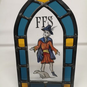 Medieval man with scooting dog stained glass panel