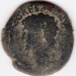 Peut inclure: Une ancienne pièce de monnaie romaine de couleur vert foncé et marron avec une image usée et délavée d'une tête de personne sur un côté.