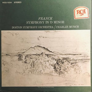 Peut inclure: Une pochette d'album de disque vinyle vintage avec une illustration en noir et blanc d'une chaîne de montagnes avec un château au loin. L'album est intitulé "FRANCK SYMPHONY IN D MINOR" et met en vedette le Boston Symphony Orchestra dirigé par Charles Munch. Le label du disque est RCA.