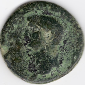 Peut inclure: Une pièce de monnaie en cuivre verte avec un design usé. La pièce est circulaire et a une surface lisse. Le design est difficile à distinguer en raison de l'usure.