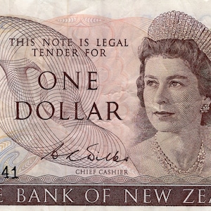 May include: A one dollar note from the Reserve Bank of New Zealand featuring a portrait of Queen Elizabeth II. The note is in brown, blue, and yellow tones with a watermark and security features.