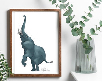 May include: A framed art print featuring a blue elephant illustration. The elephant is depicted standing on its hind legs with its trunk raised. The artwork is in a brown wooden frame, with a white background. The print is displayed near a vase with green leaves.