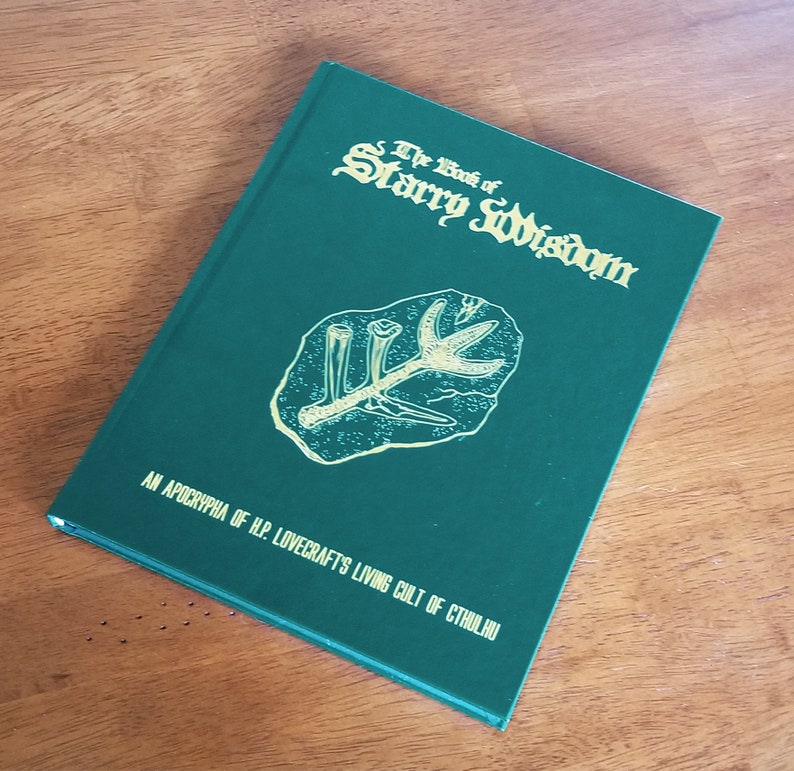 May include: A green book with the title "The Book of Starry Wisdom" in gold lettering. The book is an apocrypha of H.P. Lovecraft's Living Cult of Cthulhu.