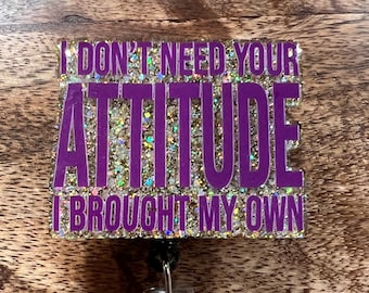 May include: Purple and gold glitter badge holder with the text "I don't need your attitude I brought my own".