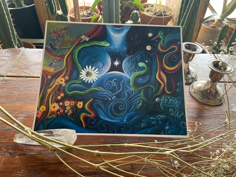 May include: A colorful, abstract painting depicting a woman's torso with a swirling galaxy inside. The woman is surrounded by flowers, butterflies, snakes, and a turtle. The painting is done in a vibrant style with a mix of blue, green, yellow, and red colors.