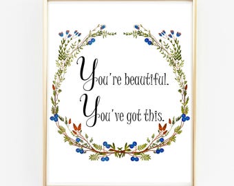 May include: A white printable art print with a floral wreath design. The wreath is made of green leaves and blue berries. The text inside the wreath reads "You're beautiful. You've got this."