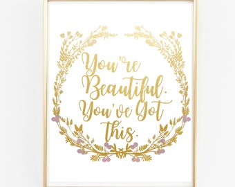 May include: Gold foil print with a floral wreath and the text "You're Beautiful. You've Got This." on a white background.