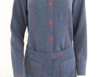 Puede incluir: Un mono a rayas azul y blanco con costuras y botones rojos. El mono tiene mangas largas y una parte superior de camisa con cuello.