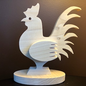 May include: A wooden rooster figurine with a detailed tail and a simple base. The rooster is made of light wood and has a natural finish.