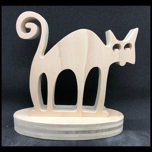May include: A wooden cat figurine with a curled tail, standing on a wooden base. The cat is light brown and has a simple, stylized design.