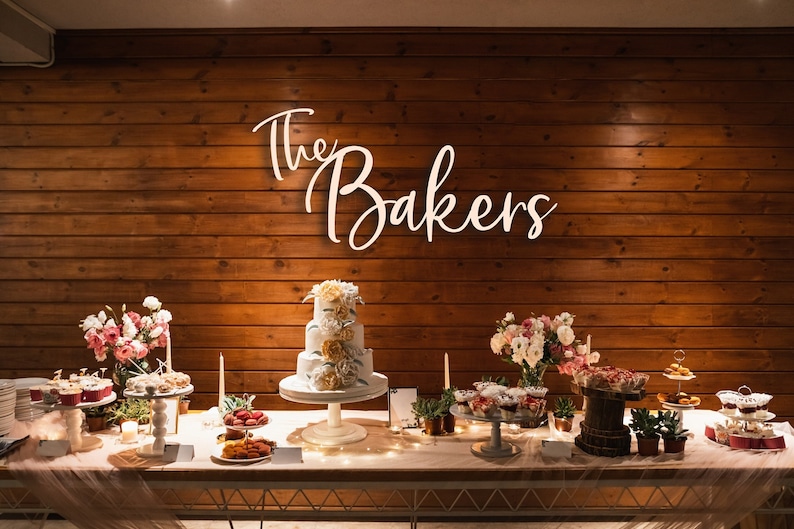 large wedding last name sign over cake table at wedding