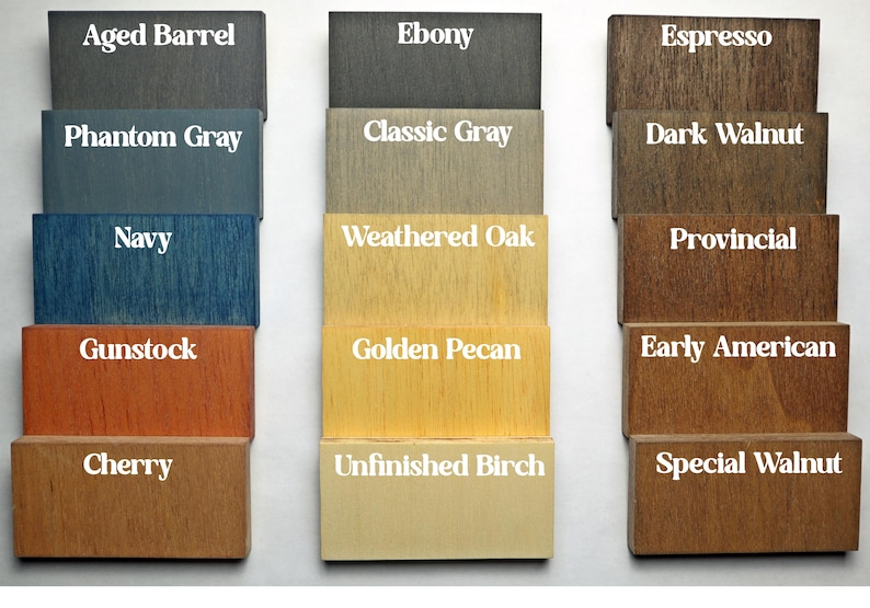 May include: A wood stain color chart with 15 different wood stain colors. The colors are arranged in three columns, with five colors in each column. The colors are labeled with their names, such as Aged Barrel, Ebony, Espresso, Phantom Gray, Classic Gray, Dark Walnut, Navy, Weathered Oak, Provincial, Gunstock, Golden Pecan, Early American, Cherry, Unfinished Birch, and Special Walnut.