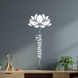 May include: White vinyl wall decal featuring a stylised lotus flower with the word "namaste" written vertically below it.