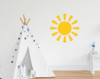 May include: A white teepee tent with a string of blue and gray pom-poms hanging from the top. A yellow sun decal is on the wall behind the teepee.