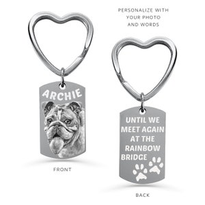 May include: Silver heart-shaped keyring with a rectangular tag. The front of the tag has a black and white photo of a bulldog with the name "Archie" printed above the photo. The back of the tag has the text "Until we meet again at the rainbow bridge" with two paw prints below the text.