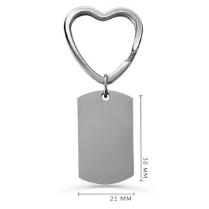 May include: Silver heart-shaped keyring with a blank rectangular tag. The tag measures 36 mm by 21 mm.
