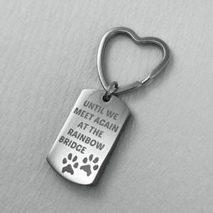 May include: Silver keyring with a heart-shaped ring and a tag that reads "Until we meet again at the rainbow bridge" with two paw prints.