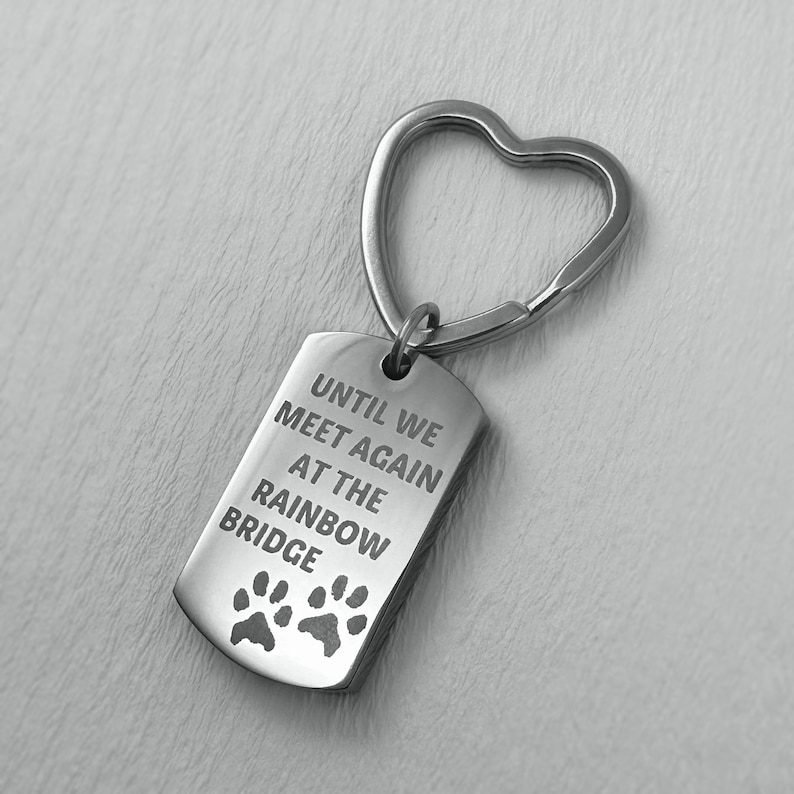 May include: Silver keyring with a heart-shaped ring and a tag that reads "Until we meet again at the rainbow bridge" with two paw prints.