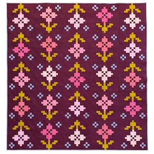 May include: A handmade quilt with a repeating floral pattern. The flowers are in shades of pink and white, with yellow stems, set against a deep burgundy background. Small blue square accents are scattered throughout the design. The quilt has a quilted texture.