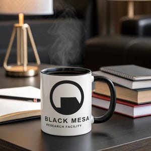 May include: A white ceramic coffee mug with a black rim and handle. The mug features a black and white logo with the text "Black Mesa Research Facility".