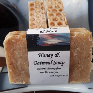 May include: Three bars of honey and oatmeal soap, each with a honeycomb pattern. The label reads "Honey & Oatmeal Soap", "Nature's Bounty from our Farm to you", and "Net Weight: 4.5 oz".