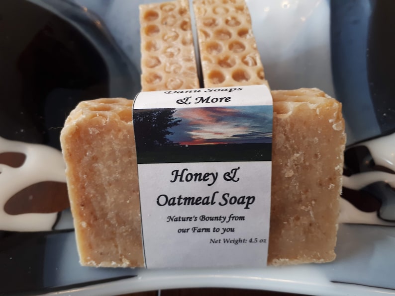 May include: Three bars of honey and oatmeal soap, each with a honeycomb pattern. The label reads "Honey & Oatmeal Soap", "Nature's Bounty from our Farm to you", and "Net Weight: 4.5 oz".