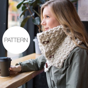 May include: A woman wearing a white crocheted cowl with brown buttons. The cowl is thick and textured. The woman is sitting at a table with a cup of coffee in her hand. The word "PATTERN" is written in a circle in the lower left corner of the image.