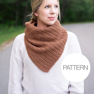 May include: A woman wearing a brown crocheted cowl neck scarf. The scarf is made with a simple stitch pattern and has a triangular shape. The text "PATTERN" is visible in a white circle.