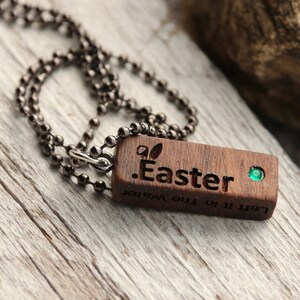 Peut inclure: Un collier avec un pendentif en bois et une pierre pr&eacute;cieuse verte. Le pendentif est grav&eacute; avec le texte ".Easter" et "Left it in the water".
