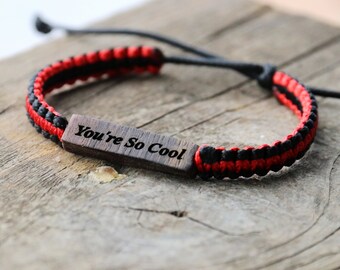 May include: Red and black braided bracelet with a wooden tag that says "You're So Cool".