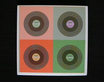 May include: A square ceramic coaster with four circular images of vinyl records. Each record has a label with the text "Music Lane Records" and "Stereo - Phonograph". The background colors are pink, green, orange, and green.