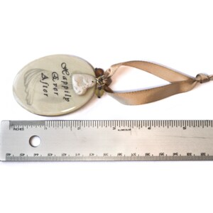 Tag laying next to ruler.  Tag measures 2.5 inches by 1.75 inches.  Overall length including ribbon is approximately 6 inches.