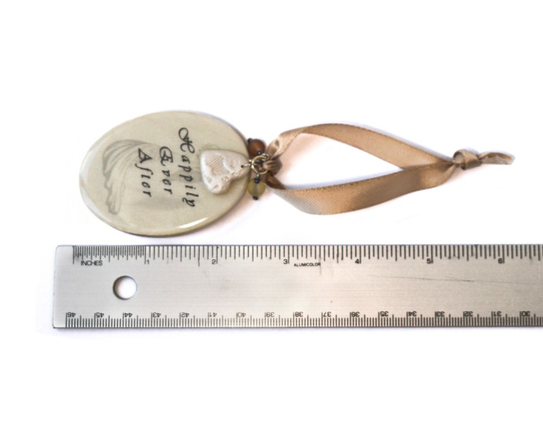 Tag laying next to ruler.  Tag measures 2.5 inches by 1.75 inches.  Overall length including ribbon is approximately 6 inches.